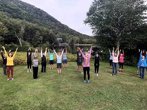 Women with their hands up on a retreat in Vermont