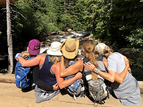 A group of women with their arms around each other on a Women's Quest retreat