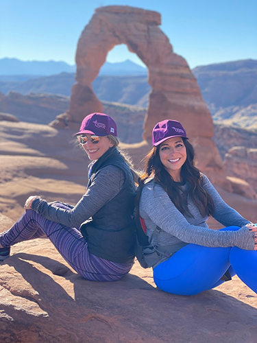 Two women posing under the arches during the Women's Quest Canyonlands retreat
