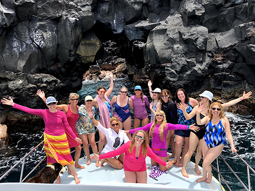Women posing on a boat during a women's retreat Hawaii