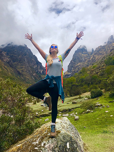 A woman doing the tree pose on a yoga retreat in Peru
