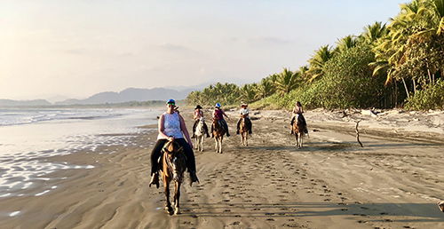 Horseback riding on the beach during our women's surf camp Costa Rica