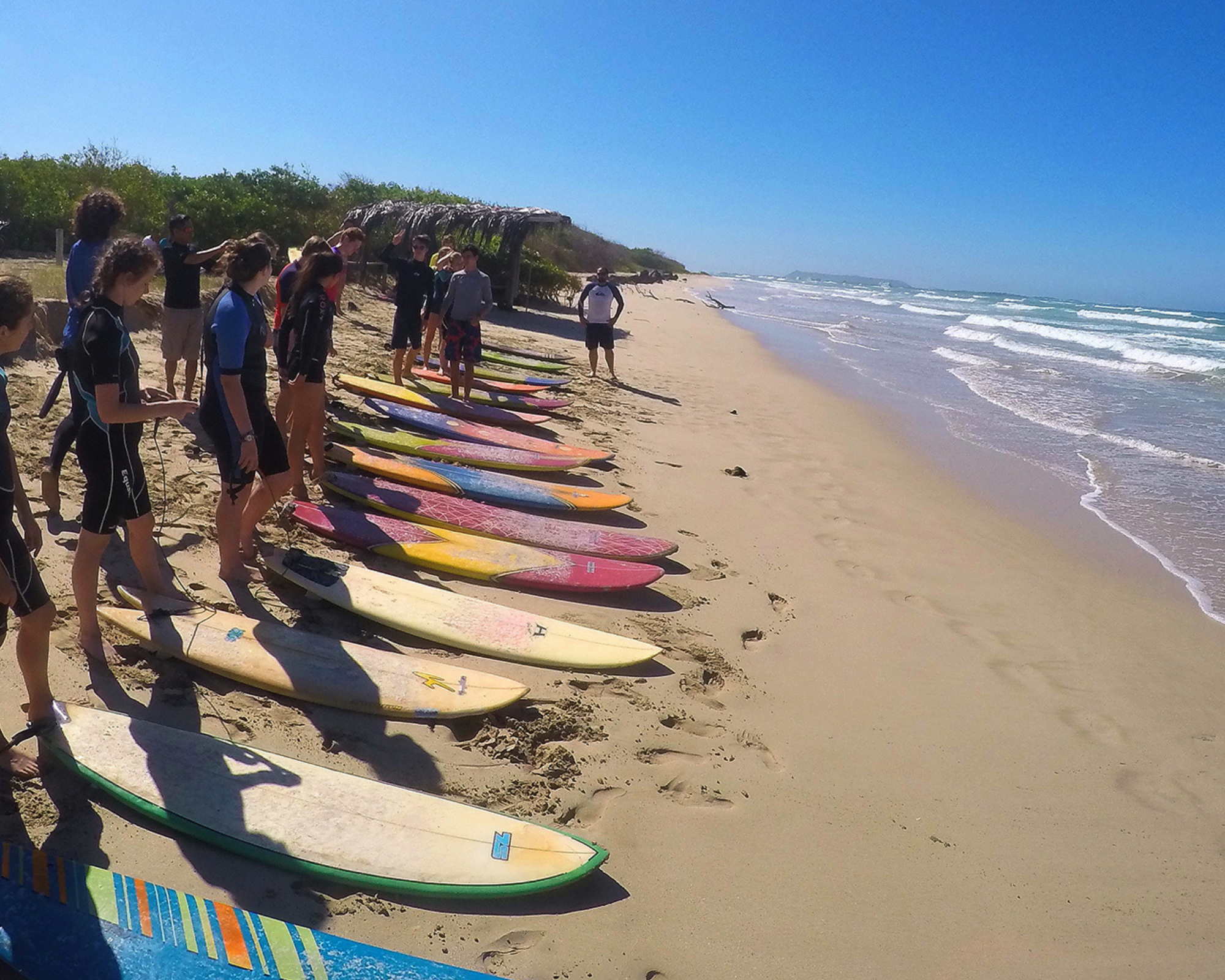 Women's Quest with surf boards on the Hawaii travel retreat thanking mother nature