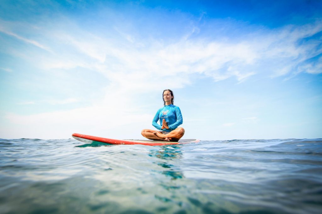 woman sitting atop a surfboard meditating in Costa Rica