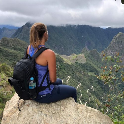 Woman sitting looking over Machu Picchu in Peru